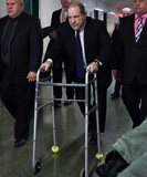 Harvey Weinstein using a walking frame flanked by security
