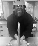 A black and white capture of abearded Liam Gallagher washing his hands